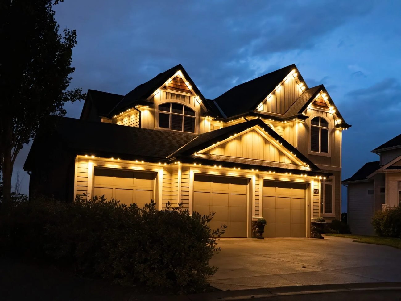 Roofline lit with warm holiday bulbs at dusk